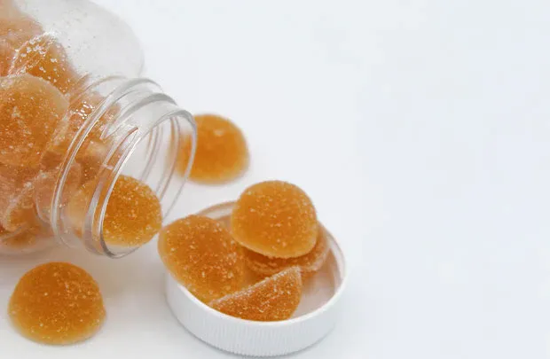 Alpha Surge bottle with gummies spilling out